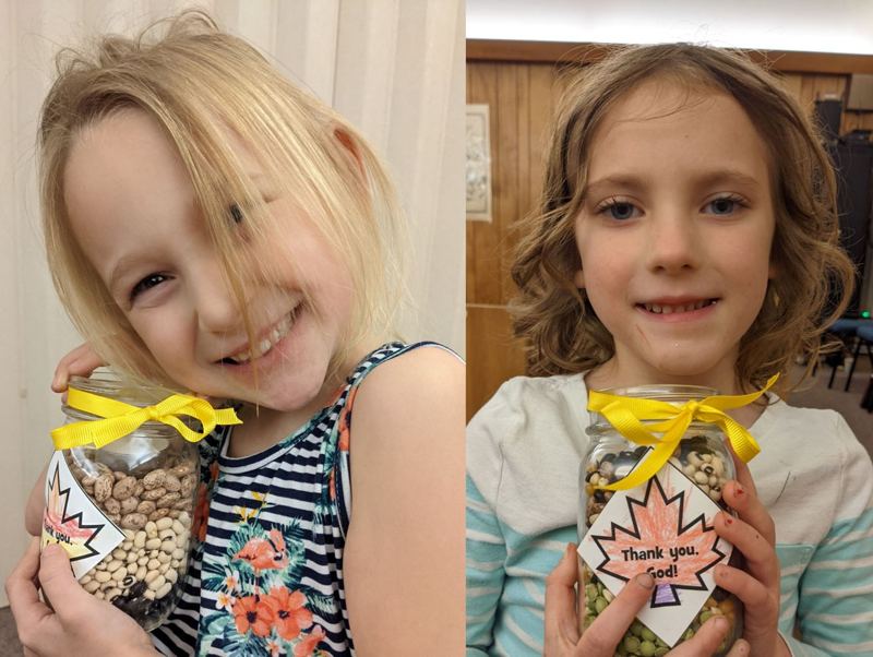 Two girls holding their thankful jars